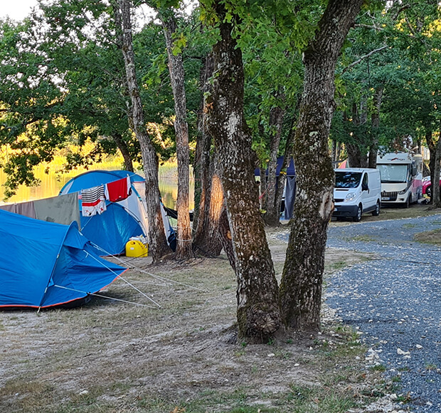 Allée des emplacements camping en Dordogne ombragés pour tente et camping-car au camping du Lac dans le Périgord vert