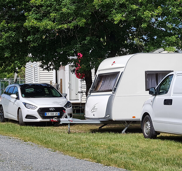 Allée des emplacements camping en Dordogne ombragés pour caravane au camping du Lac dans le Périgord vert