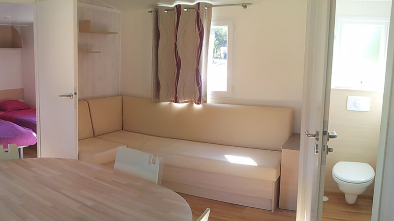 Salon avec banquette du mobil-home grand large, en location au camping du Lac en Dordogne dans le Périgord vert